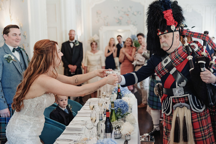 Bride shares a quaich with piper at Dean Banks at The Pompadour